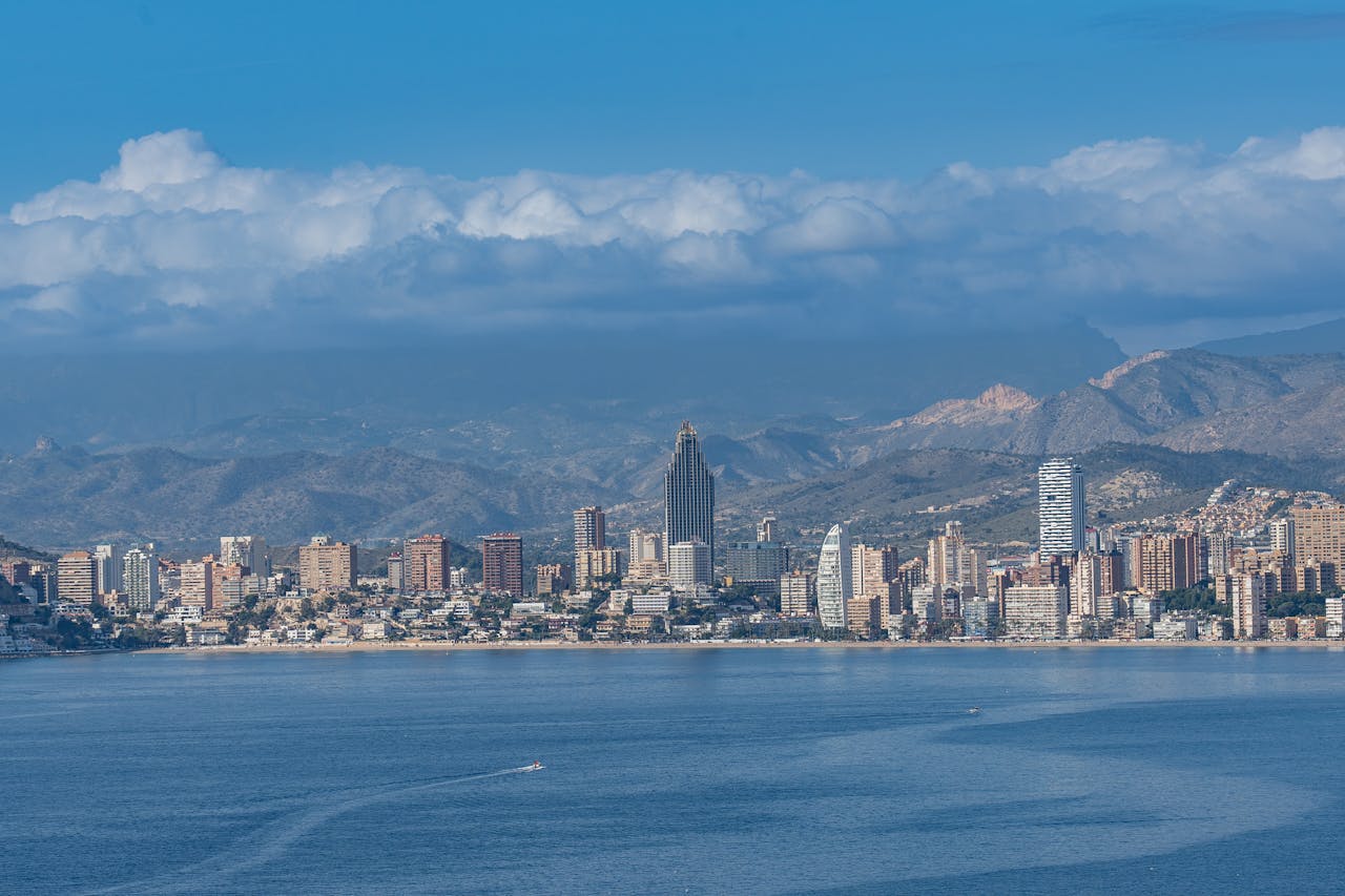 Stunning view of Benidorm's skyline with mountains in the background and a calm sea in front.